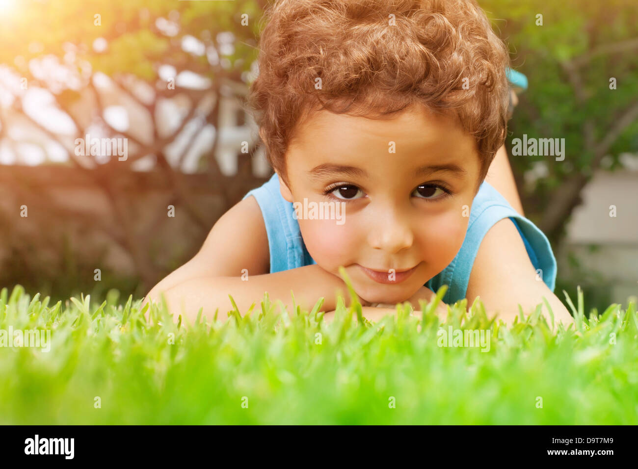 Closeup portrait of cute arabic little boy lying down on green grass field,  resting outdoors on backyard, summer holidays Stock Photo - Alamy