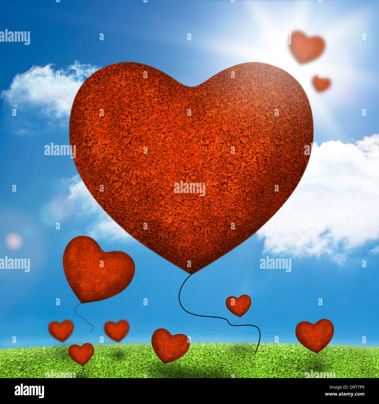 Group of heart balloons floating over field Stock Photo
