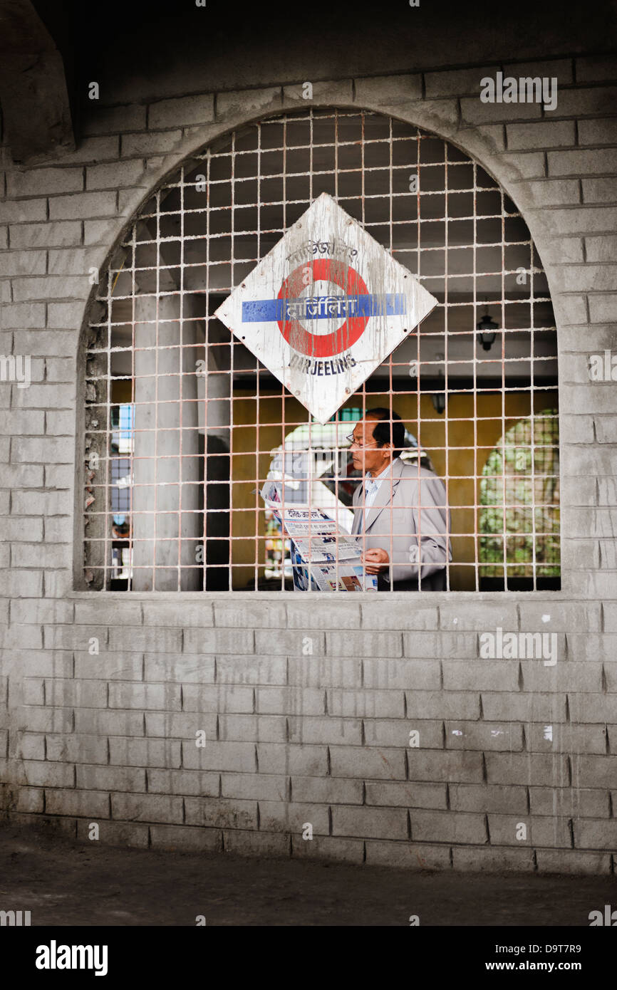 Man reading newspaper at the Darjeeling Railway Station, West Bengal, India. Stock Photo