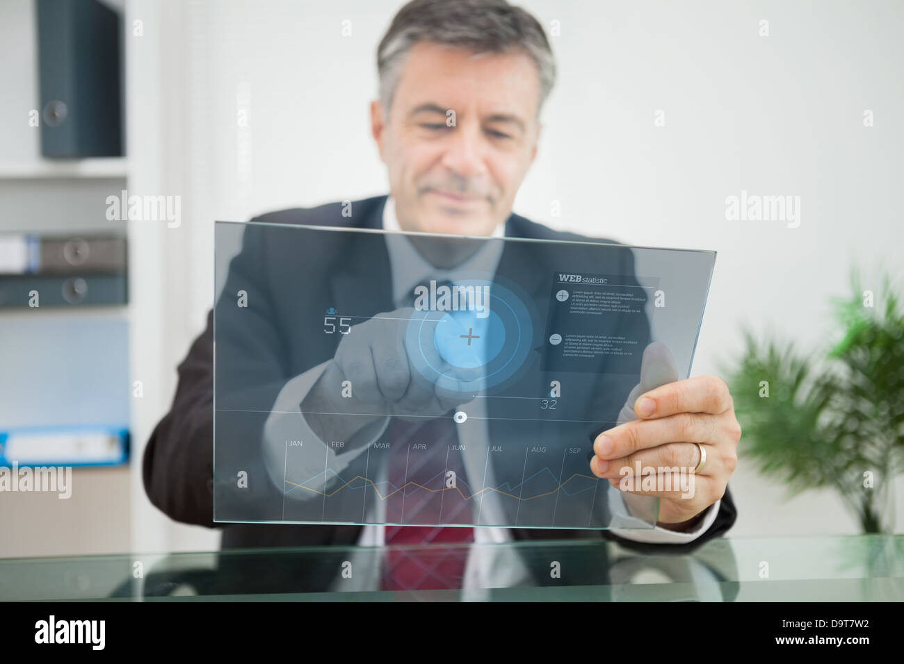 Businessman using futuristic touchscreen to view data Stock Photo