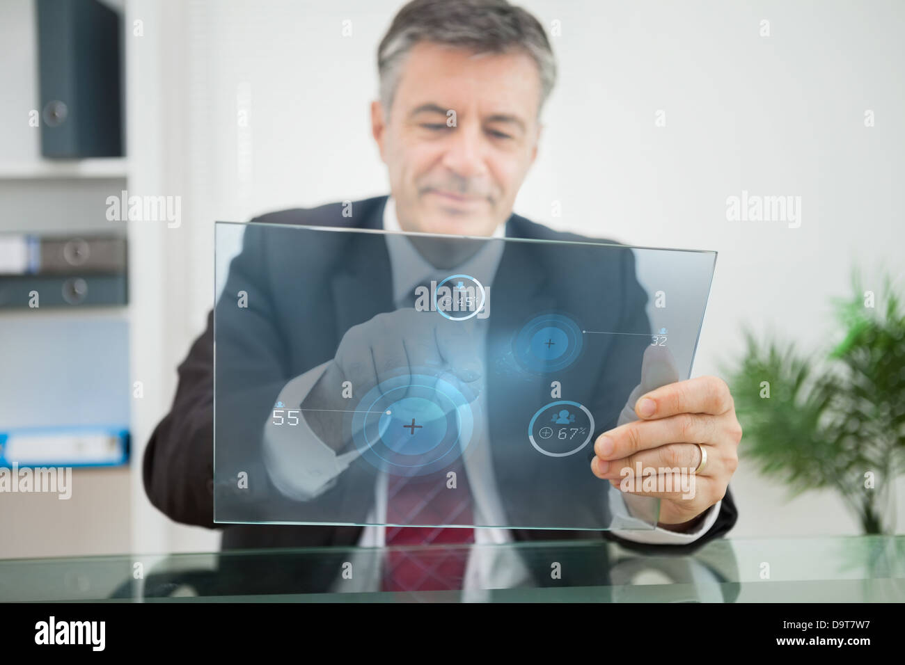 Businessman using futuristic touchscreen to view statistics Stock Photo