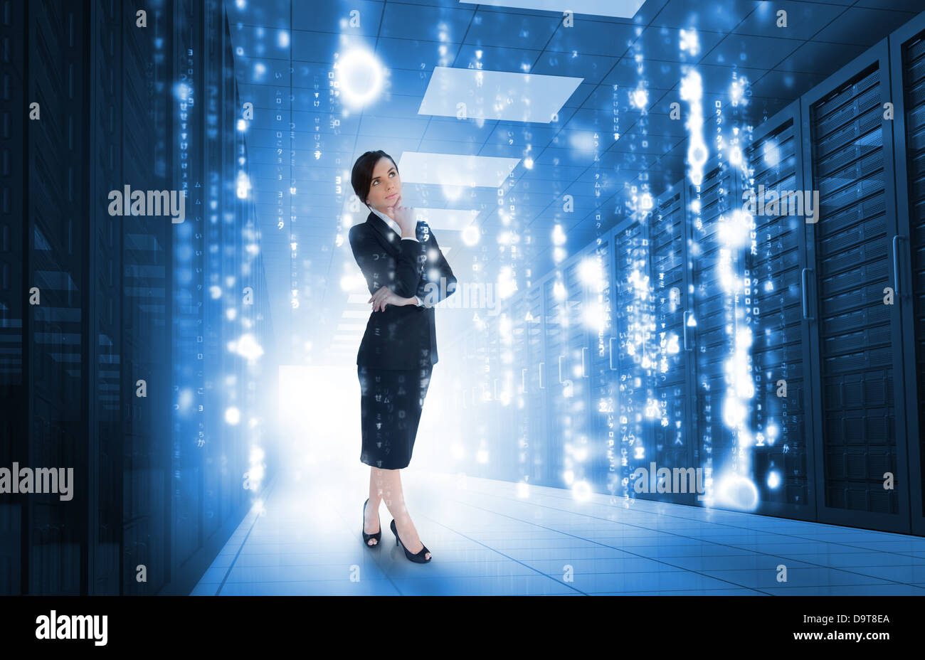 Businesswoman standing and looking thoughtful in data center Stock Photo