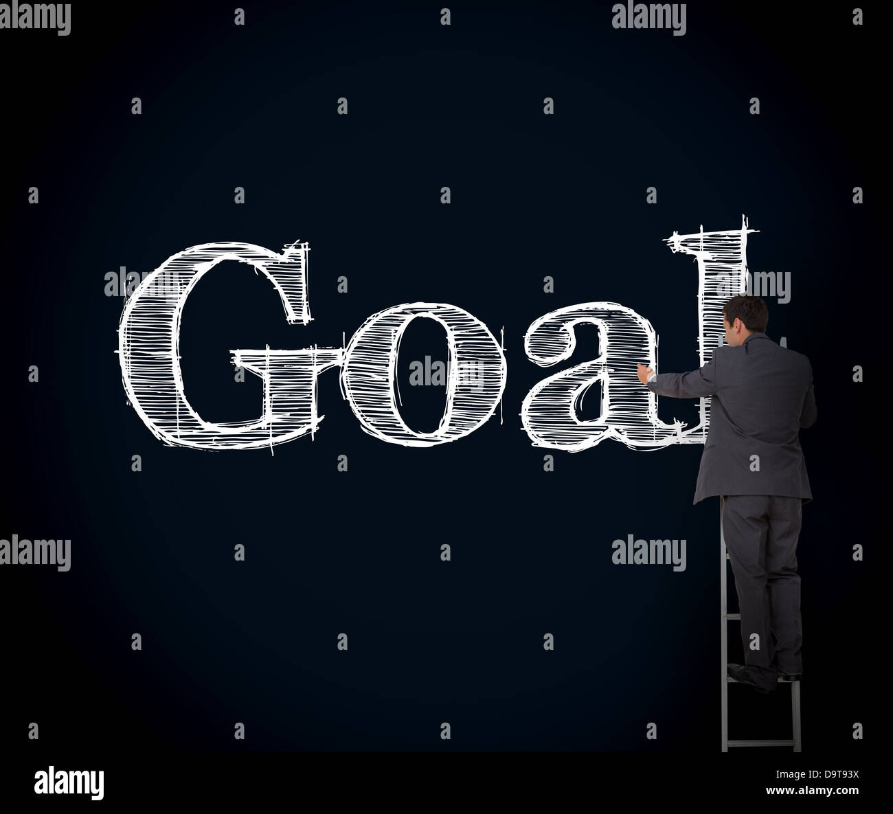 Businessman writing goal on a giant blackboard Stock Photo