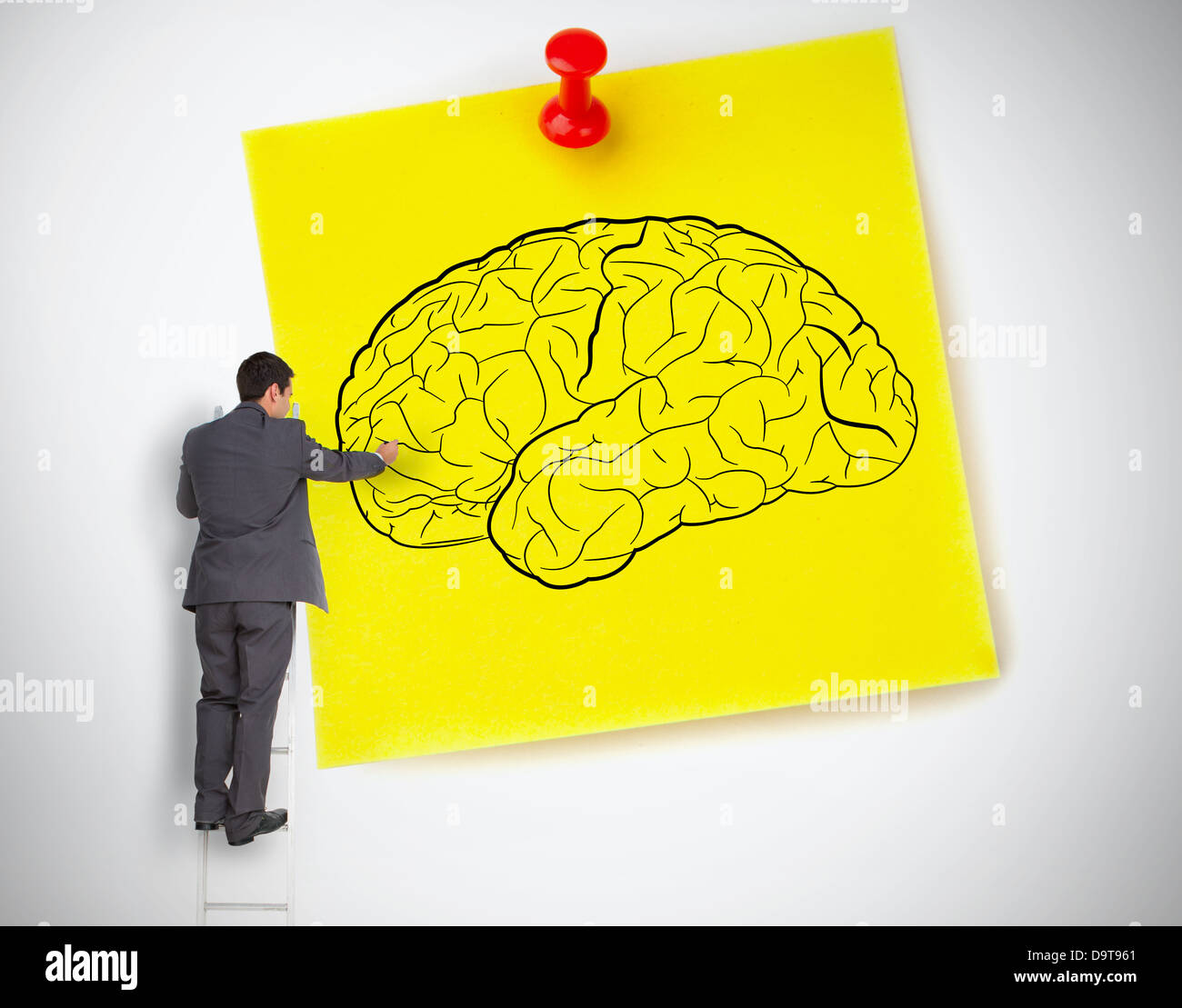 Businessman drawing a brain on a giant post it Stock Photo