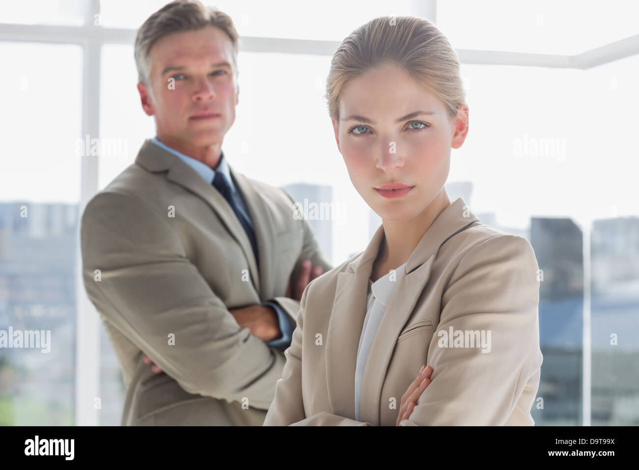 Serious business people standing with their arms crossed Stock Photo Alamy