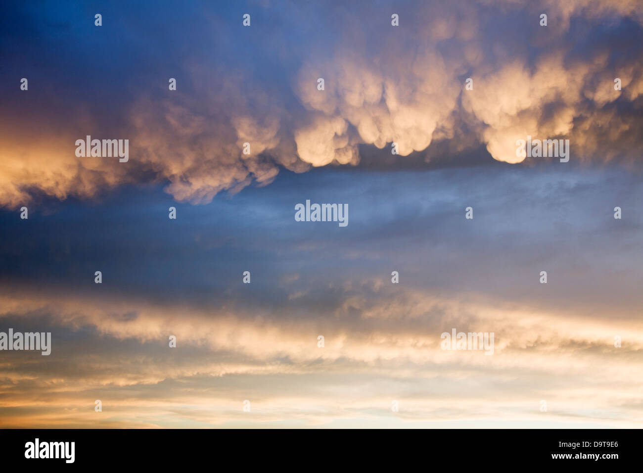 A spectacular display of Cumulonimbus with Mammatus clouds at sunset. Stock Photo