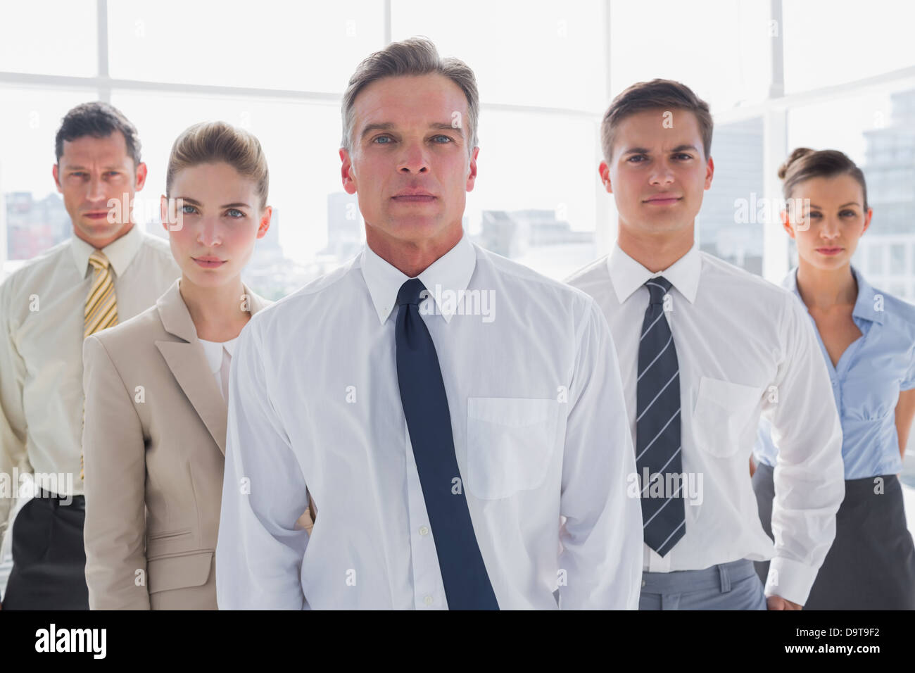 Serious business people standing together Stock Photo - Alamy