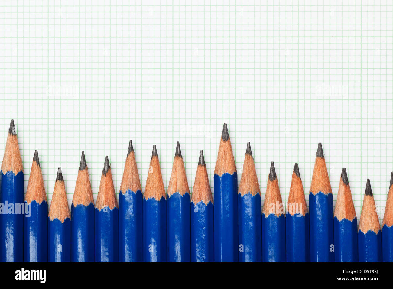 Row of pencils on a piece of graph paper Stock Photo