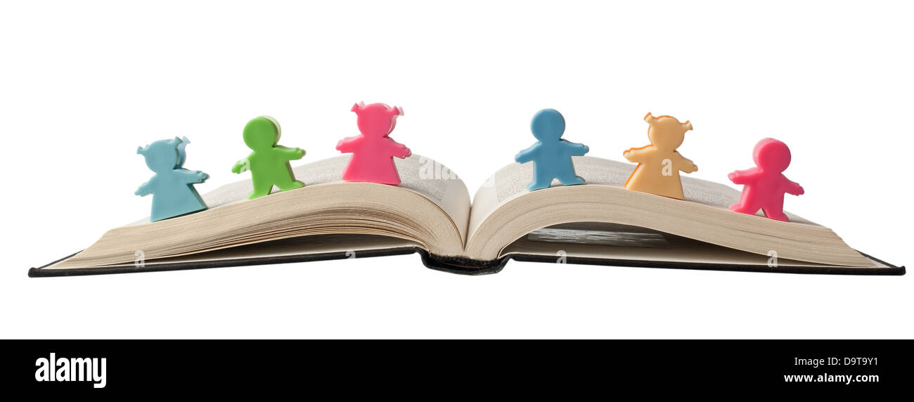 Colorful figurines on top of an open book isolated on white background Stock Photo