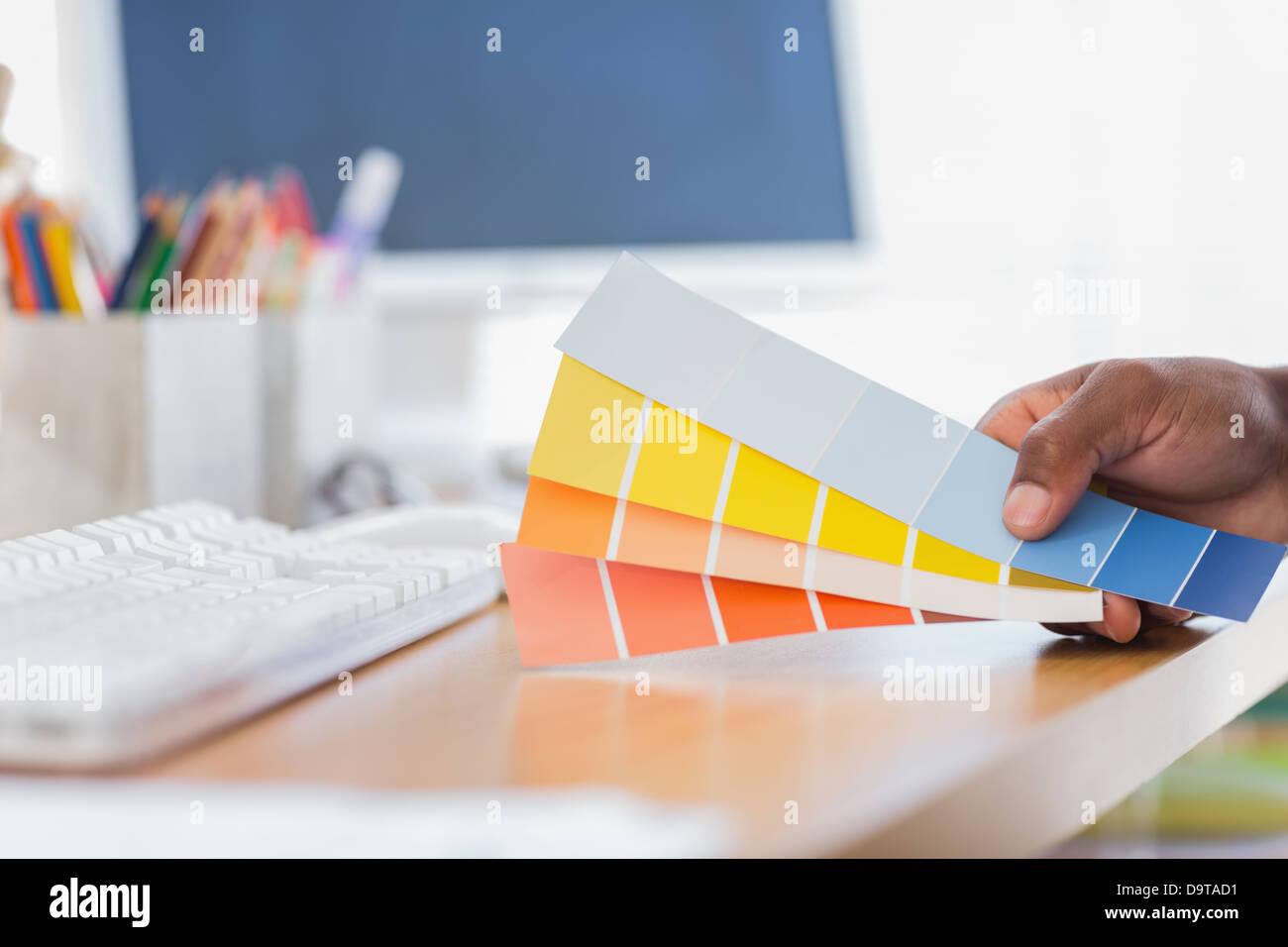 Hand holding colour charts in a modern office Stock Photo