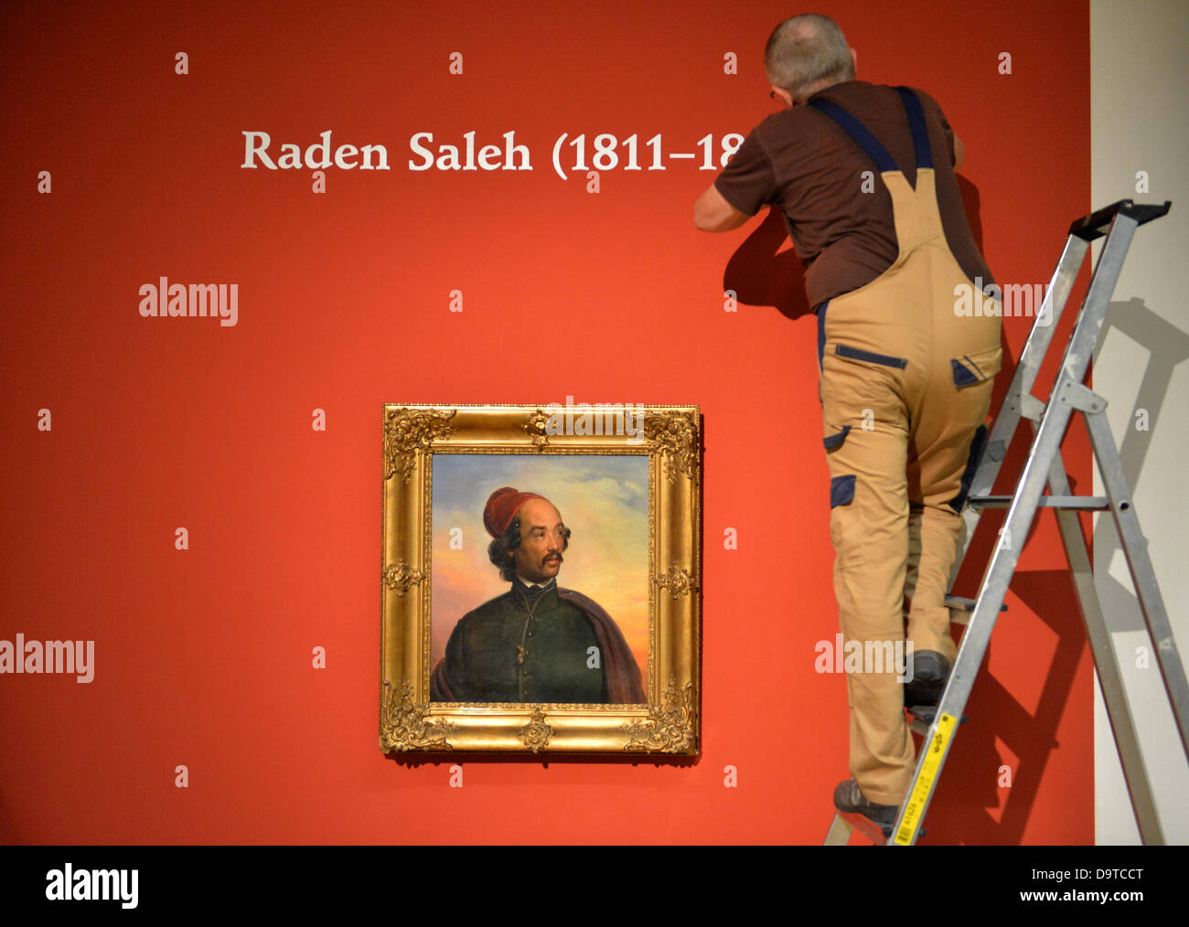 An employee of the Lindenau Museum works on a lettering above the portarit of painter Carl Christian Vogelstein (1848) by Raden Saleh at an exhibition on the Javanese painter in Altenburg, Germany, 26 June 2013. The exhibition will run from 29 June till 22 September 2013 and presents some of Saleh's paintings publicly for the first time. Photo: MARC TIRL Stock Photo