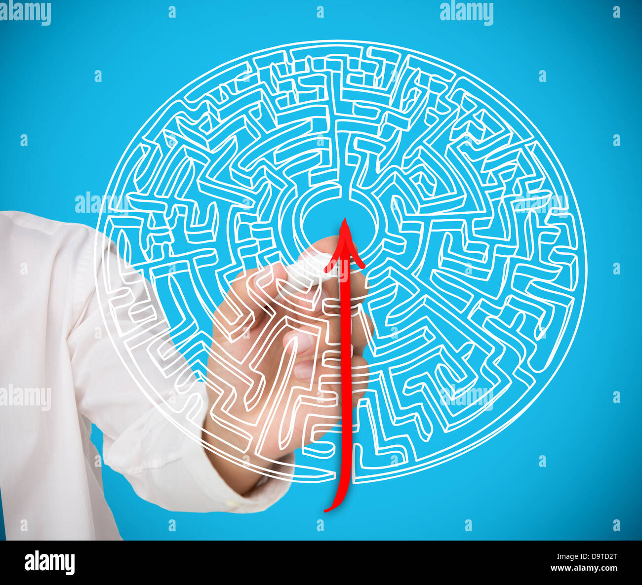Businessman drawing red line to centre of maze Stock Photo