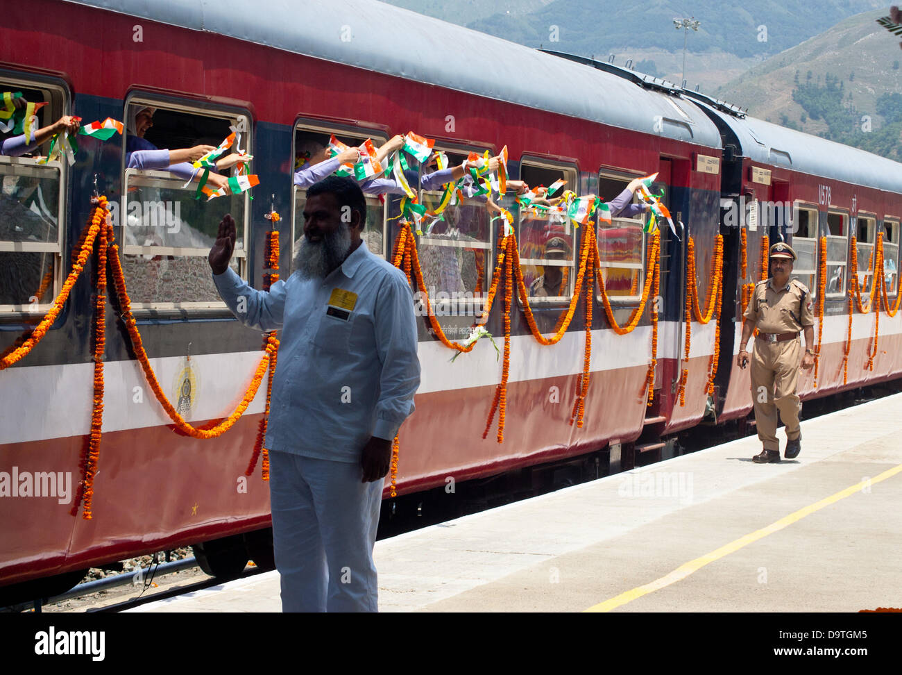 Srinagar, Indian Administered Kashmir 26th June 2013. Security officials wave at school children aboard the first train  connecting the Banihal  and Qazigund regions of Indian-administered Kashmir  on June 26,2013,  in Banihal, 125 kilometres from Srinagar,  the  summer capital city, of the disputed Himalyan region.  The train    reached Qazigund in 25 minutes, passing through  an 11-km long tunnel, AsiaÕs second longest , through the Pir Panchal mountain range  . Credit:  yawar nazir kabli/Alamy Live News Stock Photo