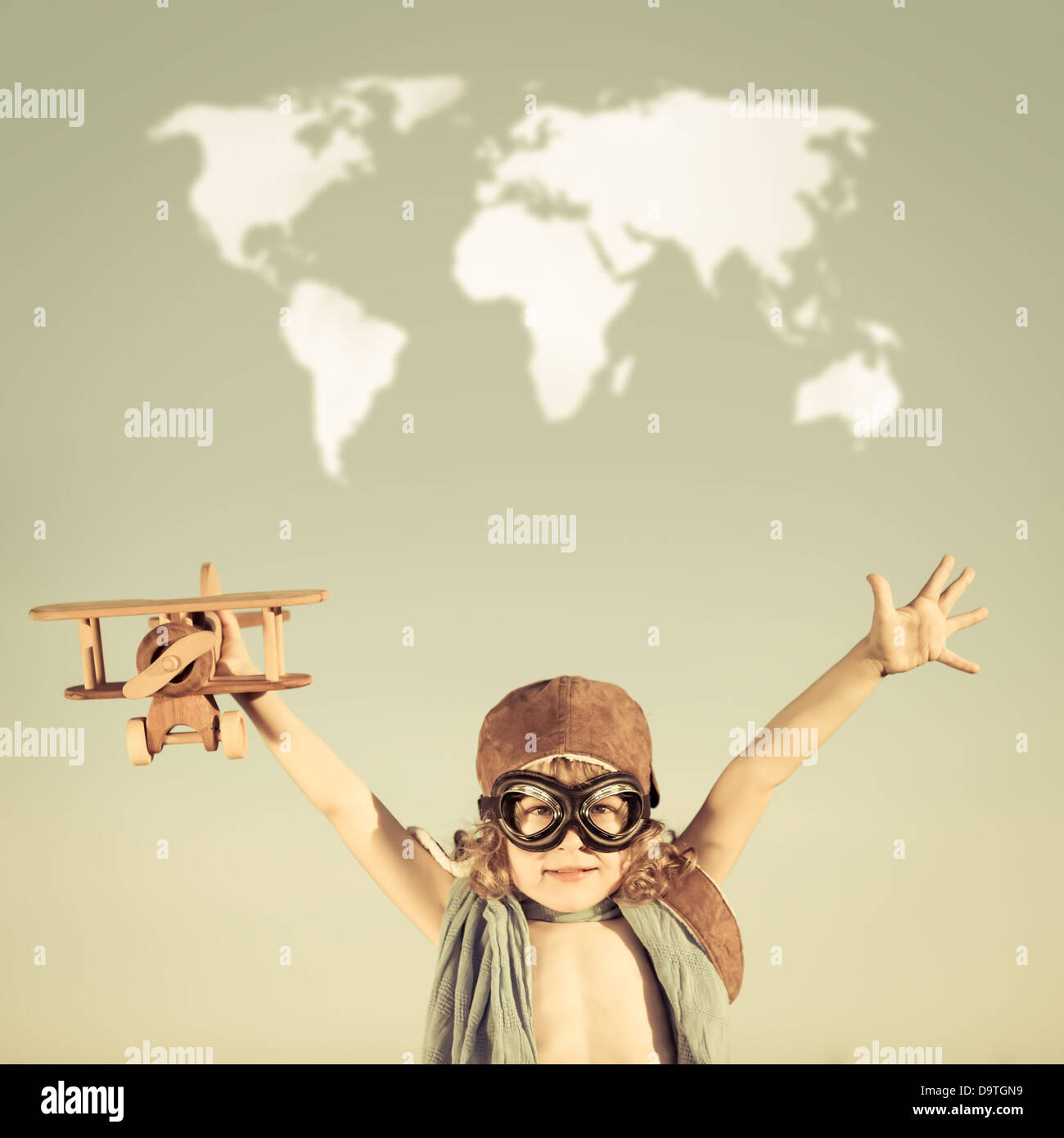 Happy kid playing with toy airplane against blue summer sky background ...