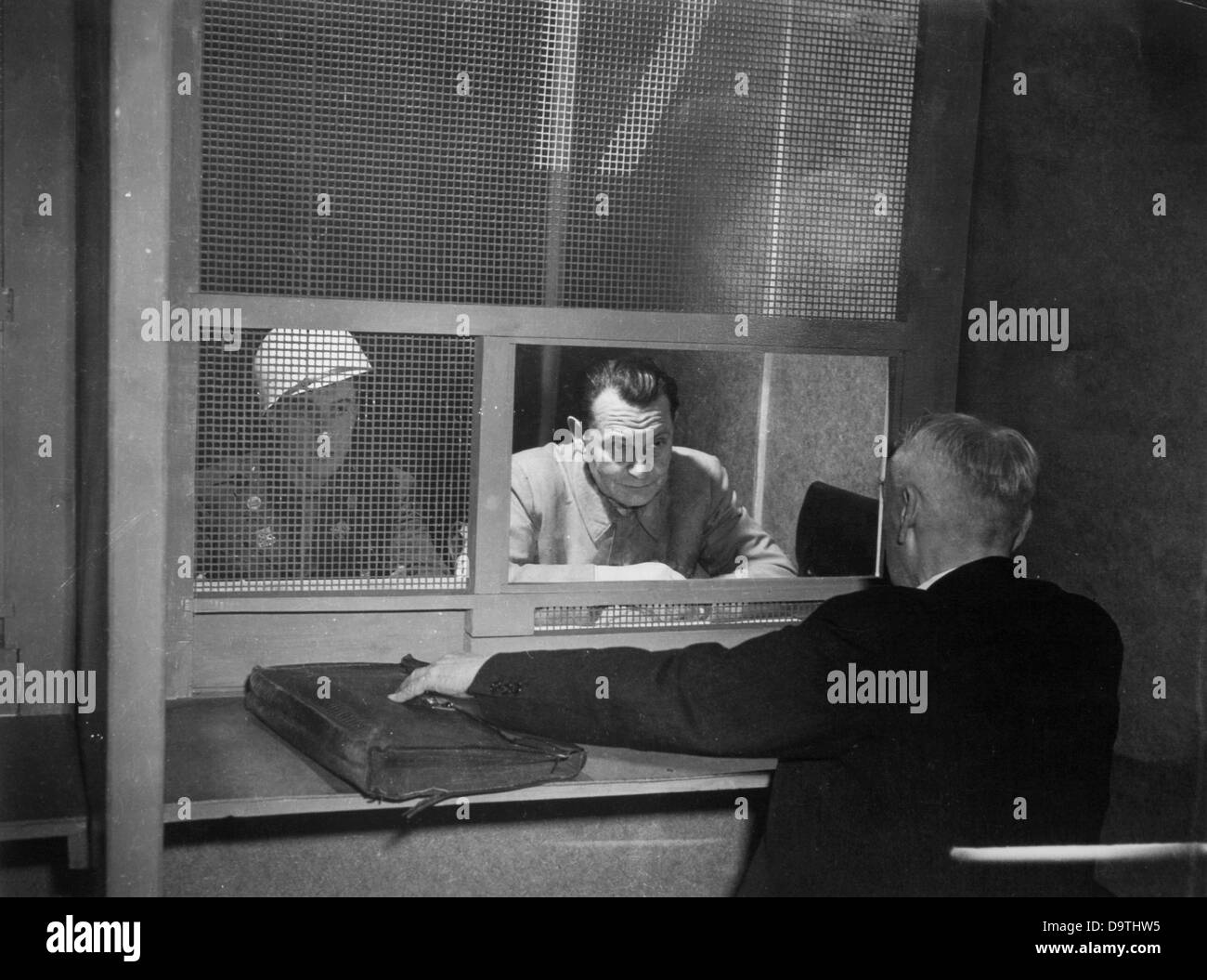 War criminal Hermann Göring is guarded by a military policeman and talks to his lawyer Strahler during the Nuremberg Trials in 1946.    Photo: Yevgeny Khaldei Stock Photo