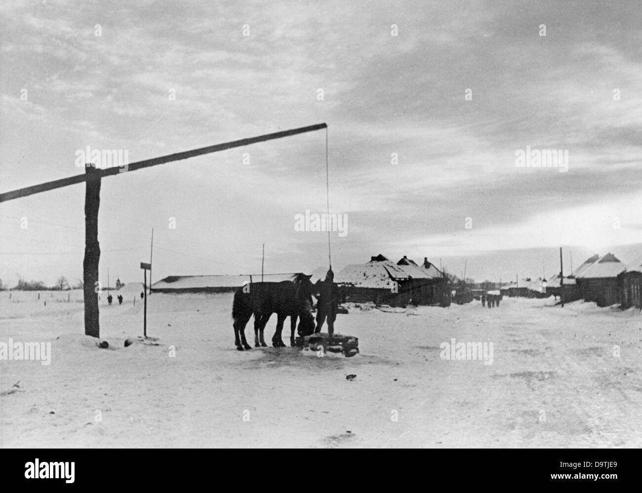 The Nazi Propaganda! on the back of the image reads: 'View of the landscape from the middle section of the Eastern Front. Water for the horses at the draw well at dawn.' Image from the Eastern Front/Russia, 25 February 1942. The attack on the Soviet Union by the German Reich was agreed on in July 1940 and prepared as the 'Operation Barbaross' since December 1940. On 22 June 1941, the invasion by the German Wehrmacht began. Fotoarchiv für Zeitgeschichte Stock Photo