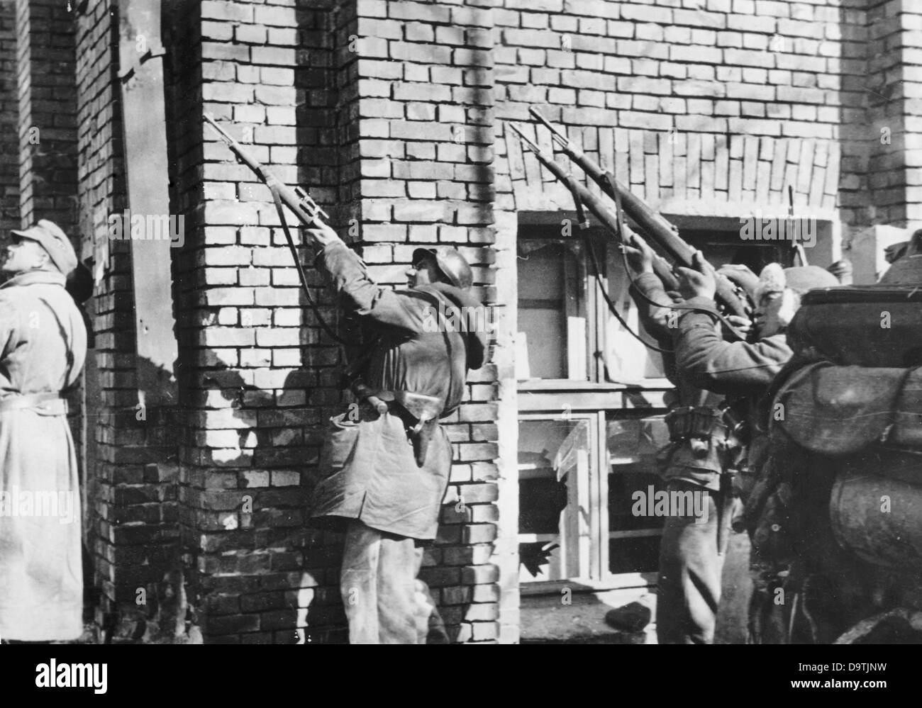 The Nazi Propaganda! on the back of the image reads: 'Street fights in Kharkiv. Against snipers on a building. Fire from below, fire from above, from the left, from all sides! These are the malices of urban warfare. The SS grenadiers, however, know about the tricks of the Soviets. Well-aimed shots finish the snipers from the roof, who mostly only fire when the Germans turn their backs on them.' Image from the Eastern Front/Ukraine, published 4 April 1943. The attack on the Soviet Union by the German Reich was agreed on in July 1940 and prepared as the 'Operation Barbarossa' since December 1940 Stock Photo