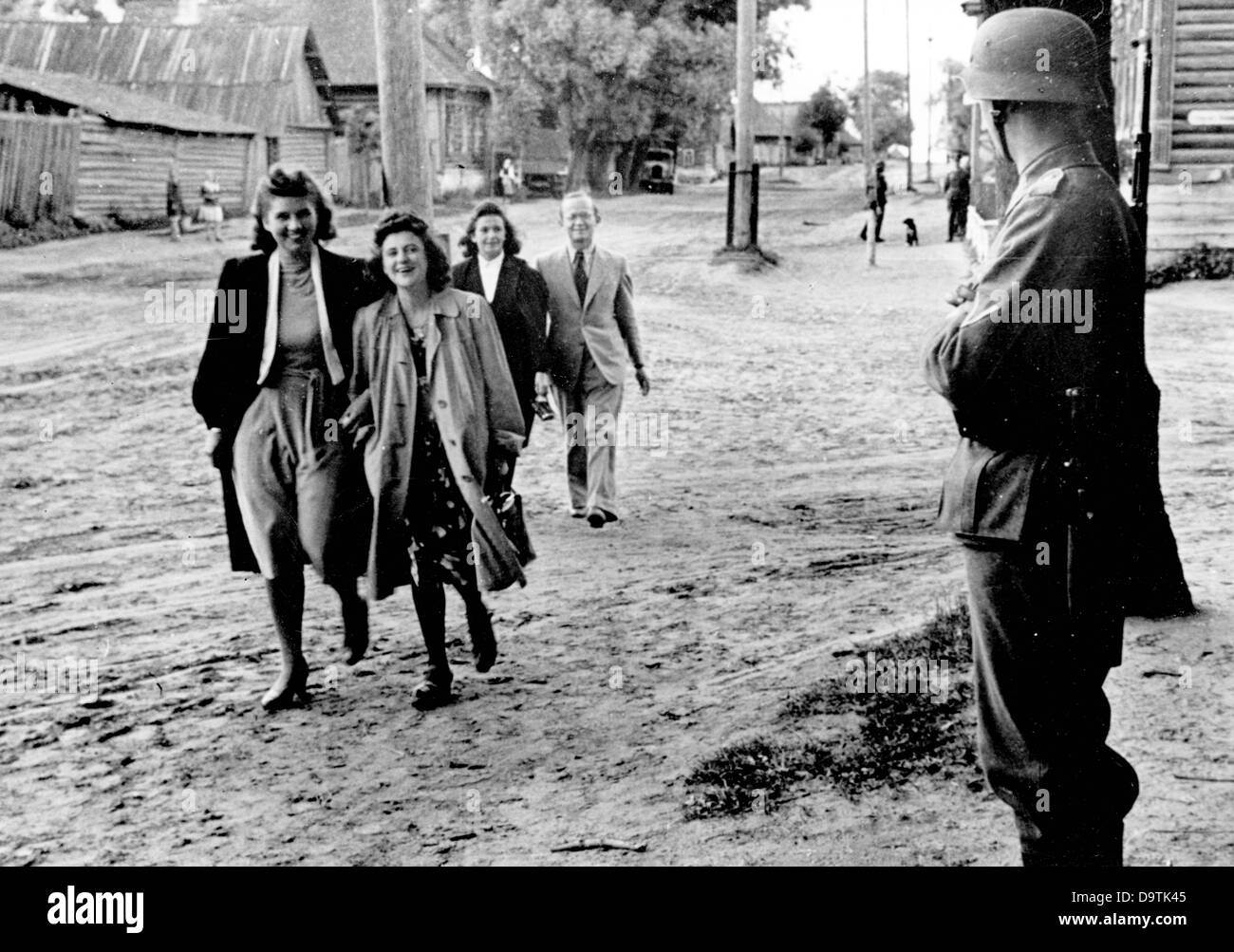 Visitors of a 'Strength through Joy' artist group are pictured on the Eastern Front, published 29 July 1942. The Nazi Propaganda! on the back of the image reads: 'To the amazement of the post. Female Europeans in the village! They are members of the Strength through Joy artist goup during the evening stroll through the village, where they - just a few kilometers behind the front line - gave a sensational guest performance for our soldiers.' The attack on Russia by the German Reich was agreed on in July 1940 and prepared since December 1940 as the 'Operation Barbarossa'. ON 22 June 1941, the in Stock Photo
