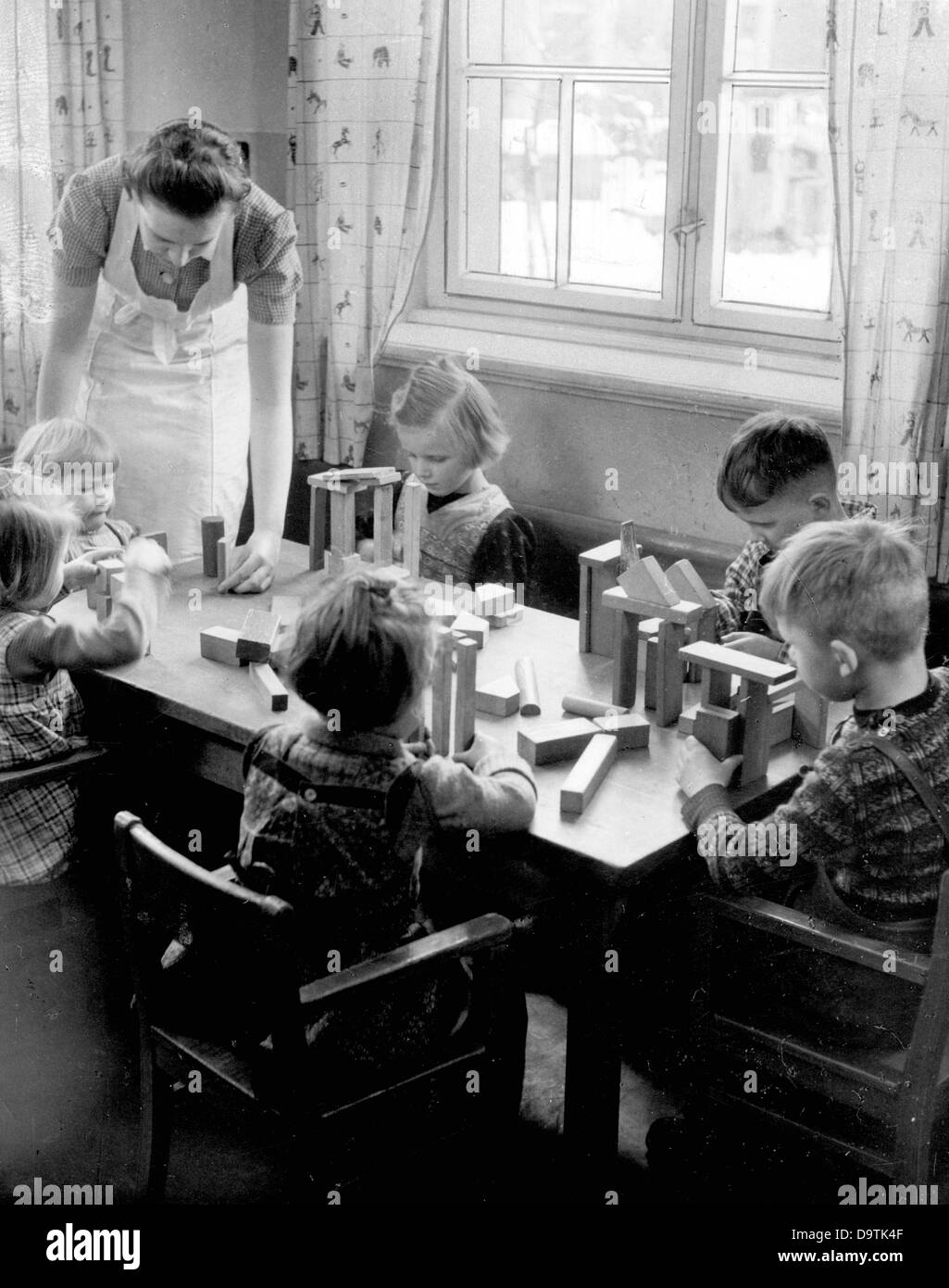 Small children are playing with bricks at the kindergarten of the National Socialist People's Welfare (NSV) in Freitag Windberg, in Saxony. Date unknown. Fotoarchiv für Zeitgeschichte Stock Photo