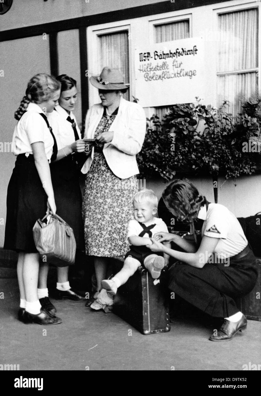 Girls of the German Girls League (BDM) help travelling women and children at the hitchhiker station in Berlin, in August 1939, in the station service of the National Socialist People's Welfare (NSV). Fotoarchiv für Zeitgeschichte Stock Photo