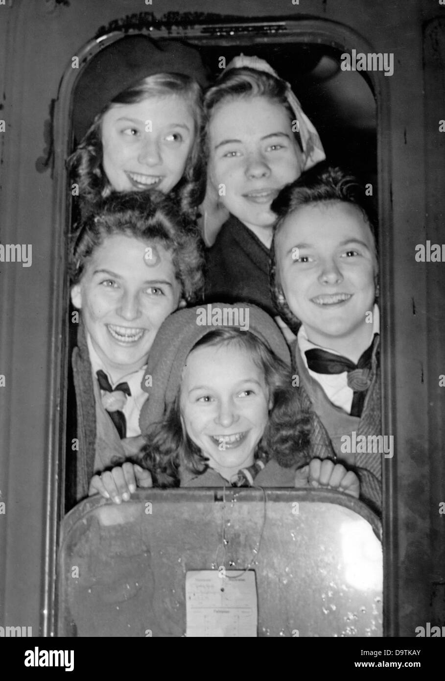 Girls pose for the photographer at a train window before their departure to a Children's Evacuation Program camp in February 1944. Fotoarchiv für Zeitgeschichte Stock Photo