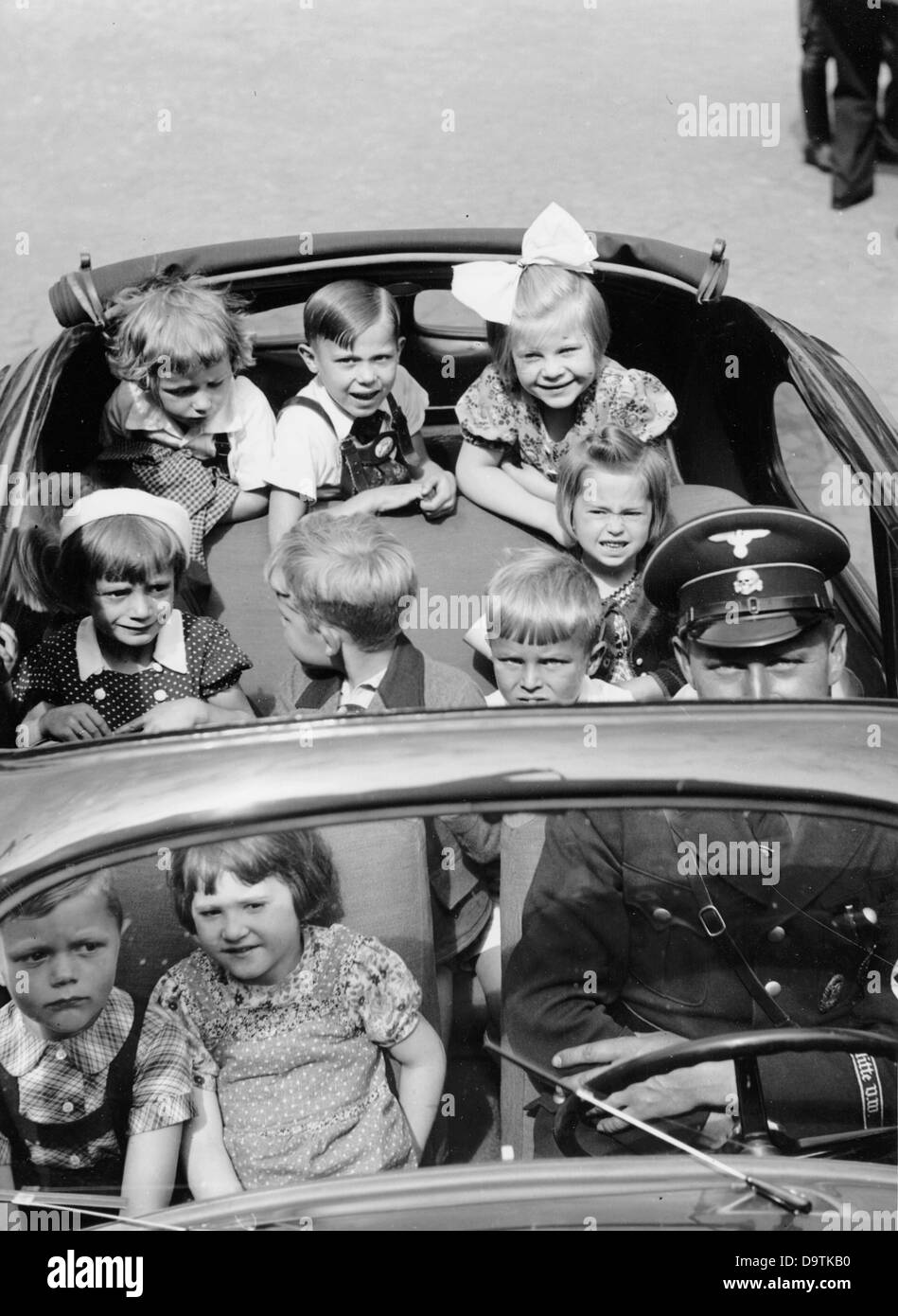 Children are sitting in the KdF (Strength through Joy) -car  in 1939. The driver, as a member of the SS, is wearing the skull in his uniform. Fotoarchiv für Zeitgeschichte Stock Photo