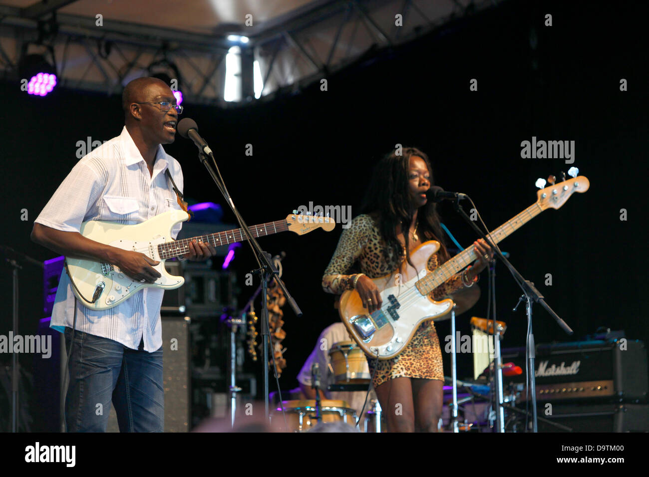 Black artists playing guitar and singing on stage during multicultural open air summer music festival Fête de la Musique in downtown (old city) Geneva, Switzerland. Credit:  ImageNature, Alexander Belokurov / Alamy Stock Photo