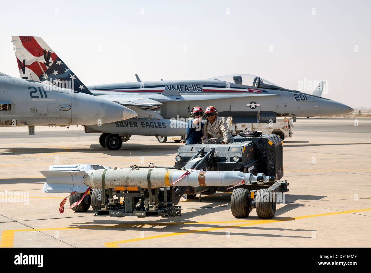 Two Marines from the VMFA-115 squadron set bombs in place that will be used on the F-18 aircraft pictured here. Stock Photo