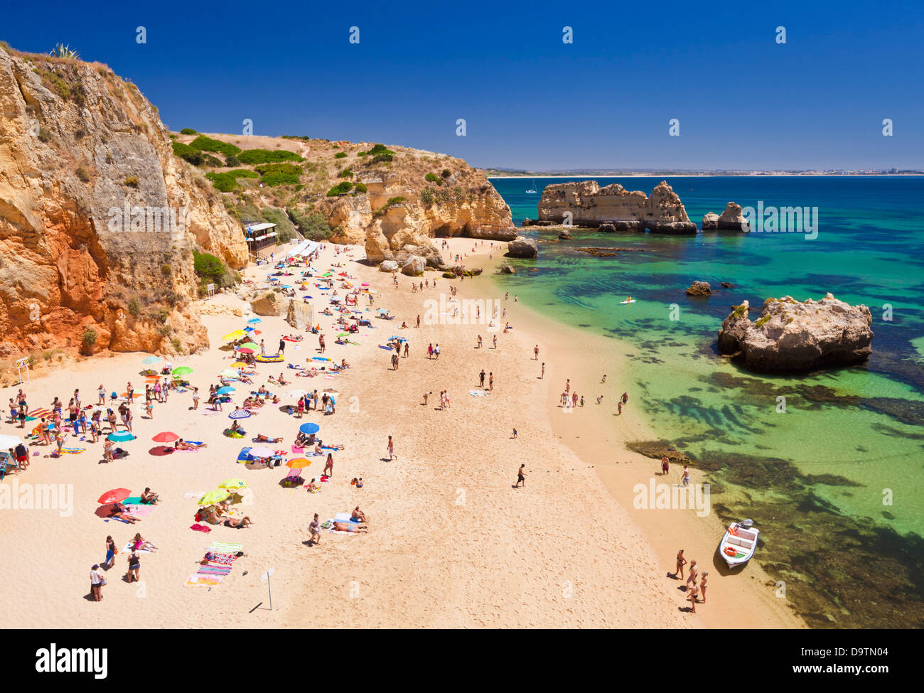 Travel Holidaymakers sunbathing on Praia da Dona Ana sandy beach near the resort of Lagos Algarve Portugal EU Europe Stock Photo
