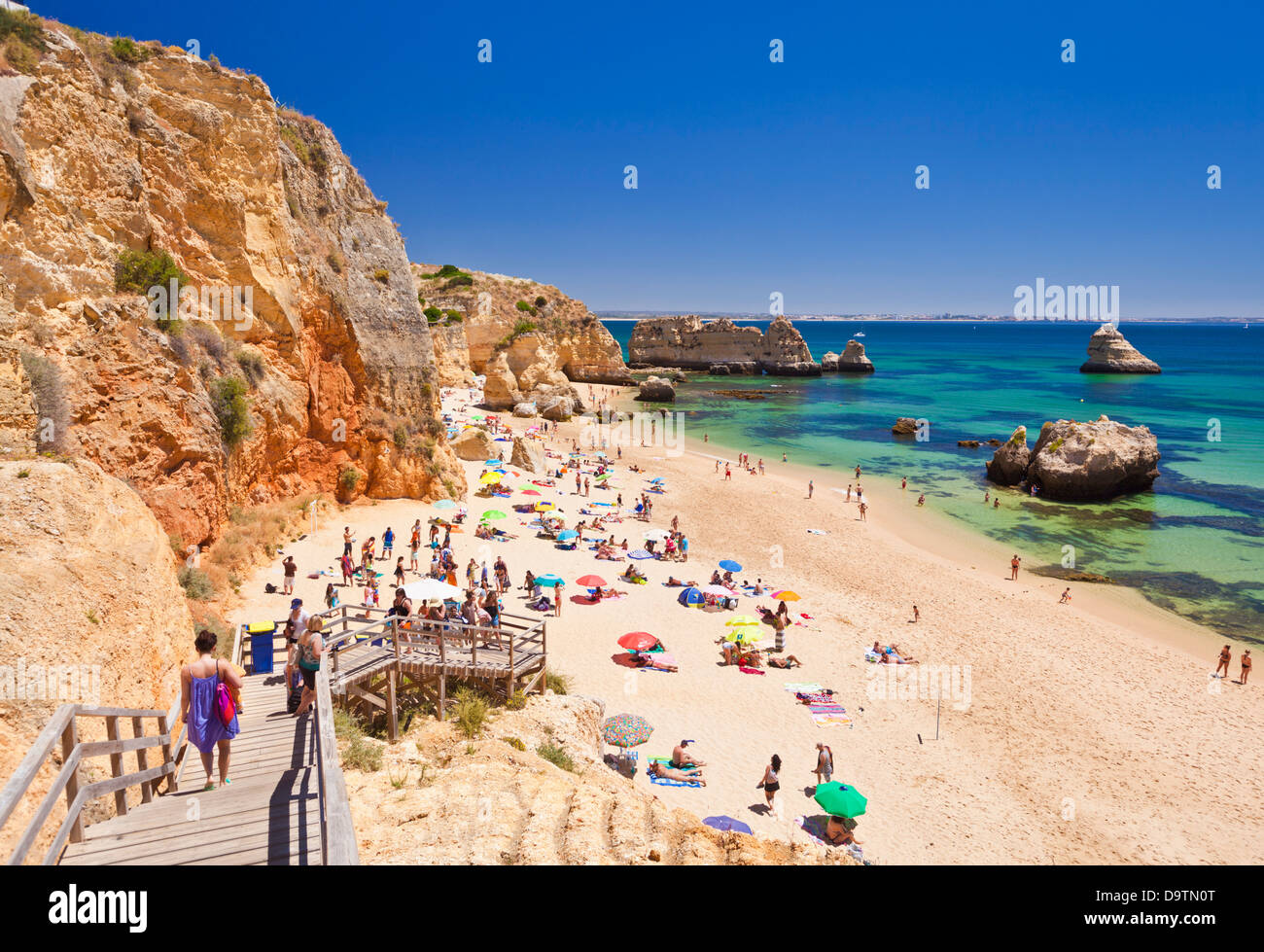 Holidaymakers sunbathing on Praia da Dona Ana Lagos Algarve Portugal EU Europe Stock Photo