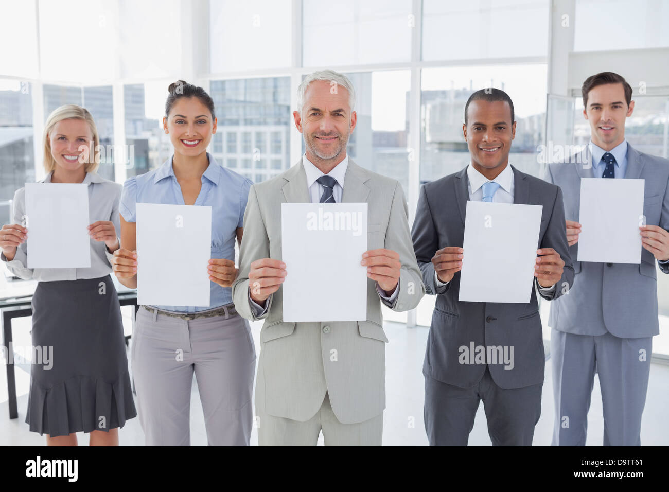 Buisness team holding up blank pages Stock Photo