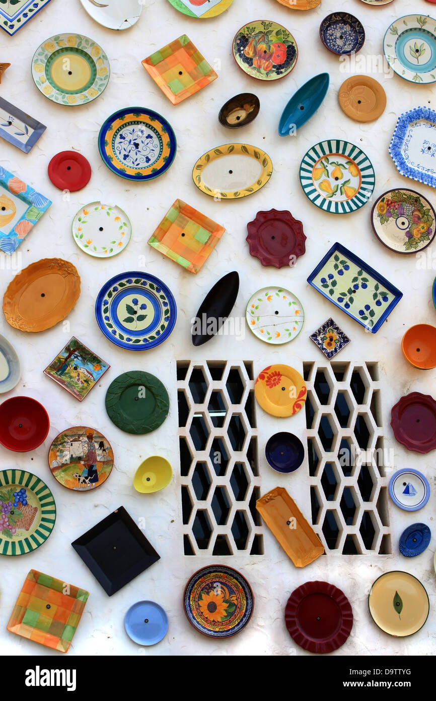 Colorful display of hand painted plates covers the outside wall of an artisan shop in Vila Do Bispo, Algarve, Portugal, Europe, Stock Photo