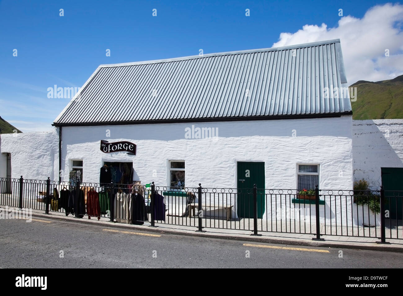 A clothing shop with clothing hung outside on display;Leenane county