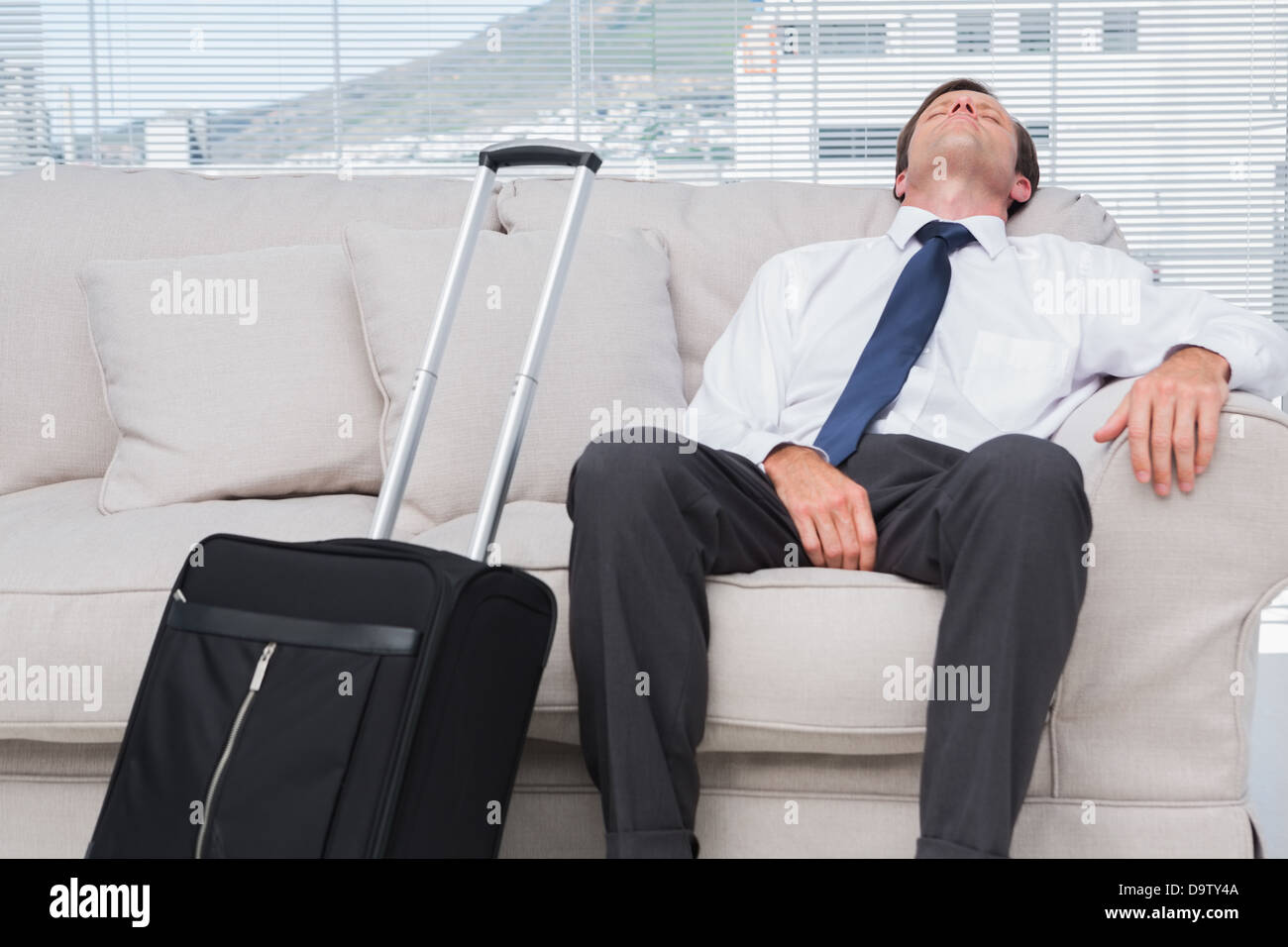 Businessman napping on couch Stock Photo Alamy
