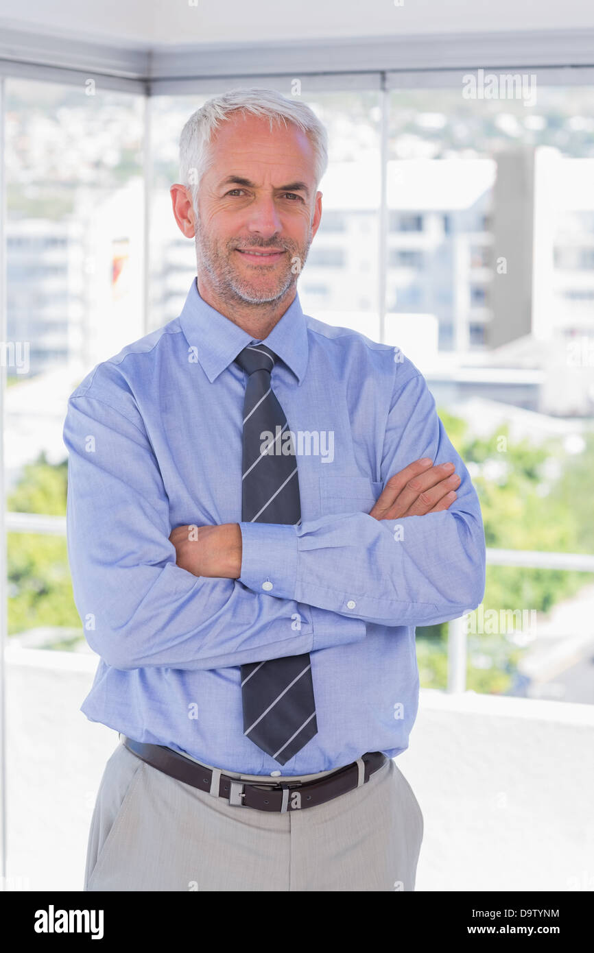 Businessman smiling with arms crossed Stock Photo - Alamy