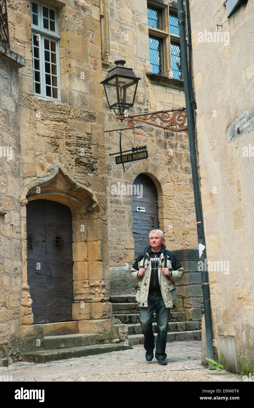Man walks narrow streets of Sarlat-de-Caneda, Dordogne FRANCE, well-preserved medieval town Stock Photo