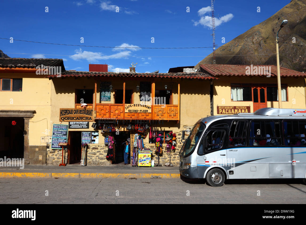 Tour bus outside restaurant and handicraft shop in Plaza de Armas, Ollantaytambo , Sacred Valley , near Cusco, Peru Stock Photo