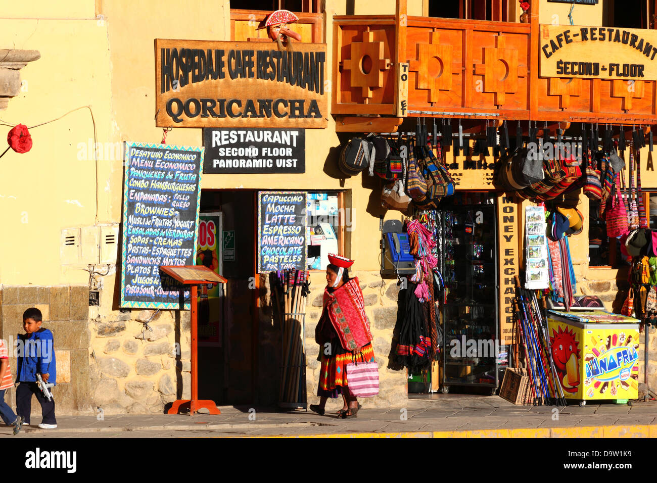 Local indigenous lady walking past souvenir shop and street cafe menus