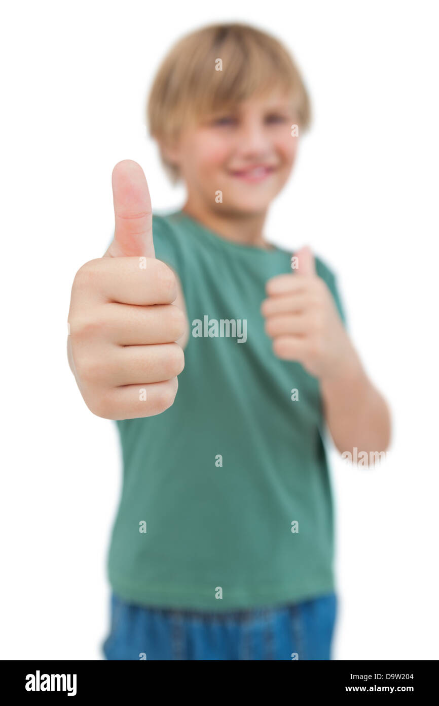 Blonde boy giving thumbs up focus shot Stock Photo