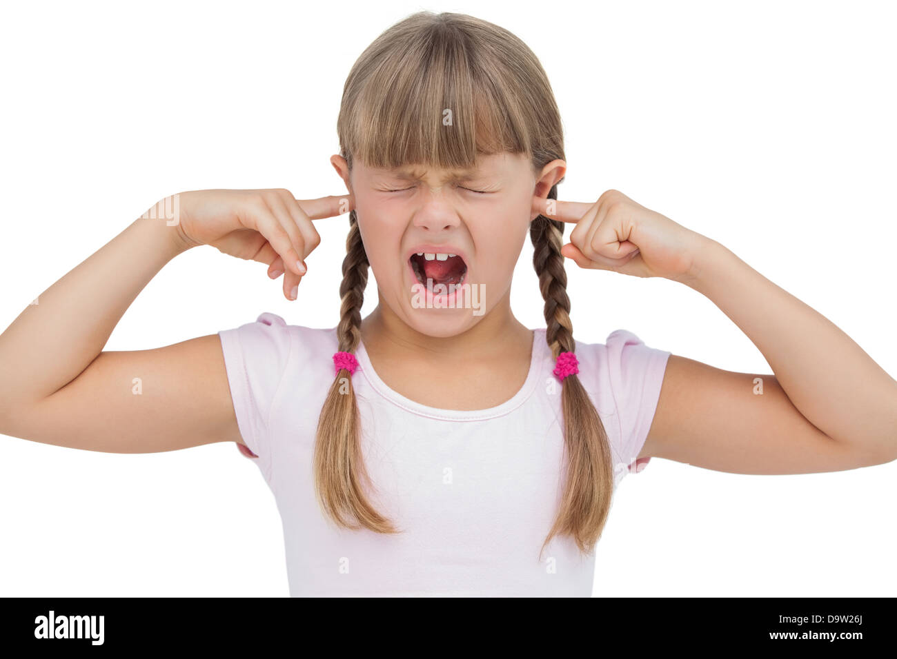 Funny little girl clogging her ears and wincing Stock Photo