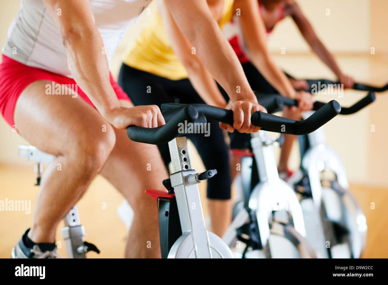 Three people spinning in the gym exercising for their legs and