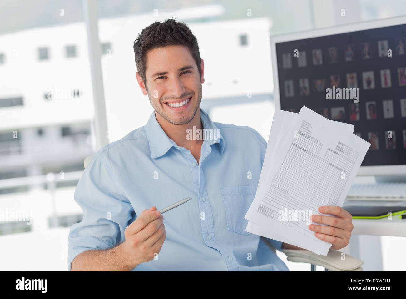 Cheerful photo editor pointing at documents Stock Photo