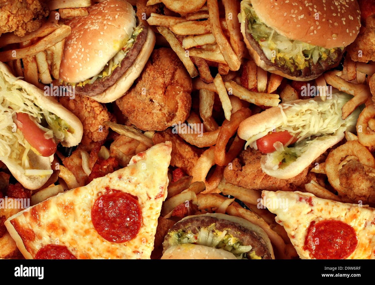 Fast food concept with greasy fried restaurant take out as onion rings burger and hot dogs with fried chicken french fries and p Stock Photo