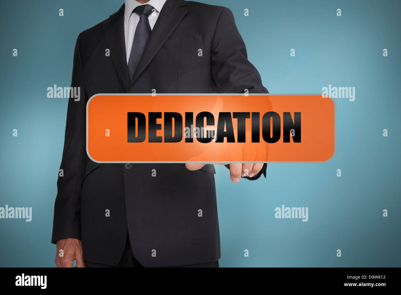Businessman touching the word dedication Stock Photo
