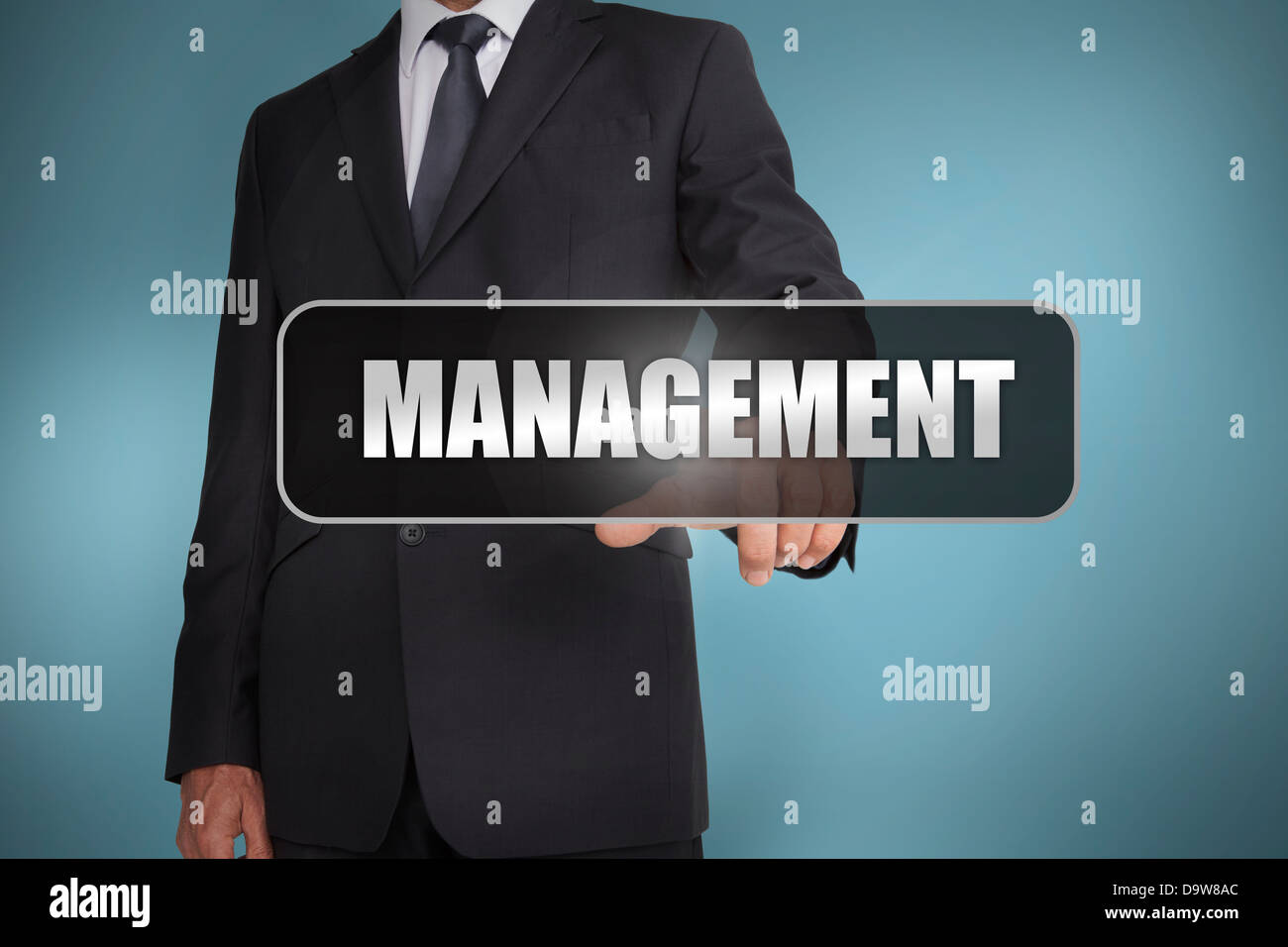 Businessman touching the word management written on black tag Stock Photo