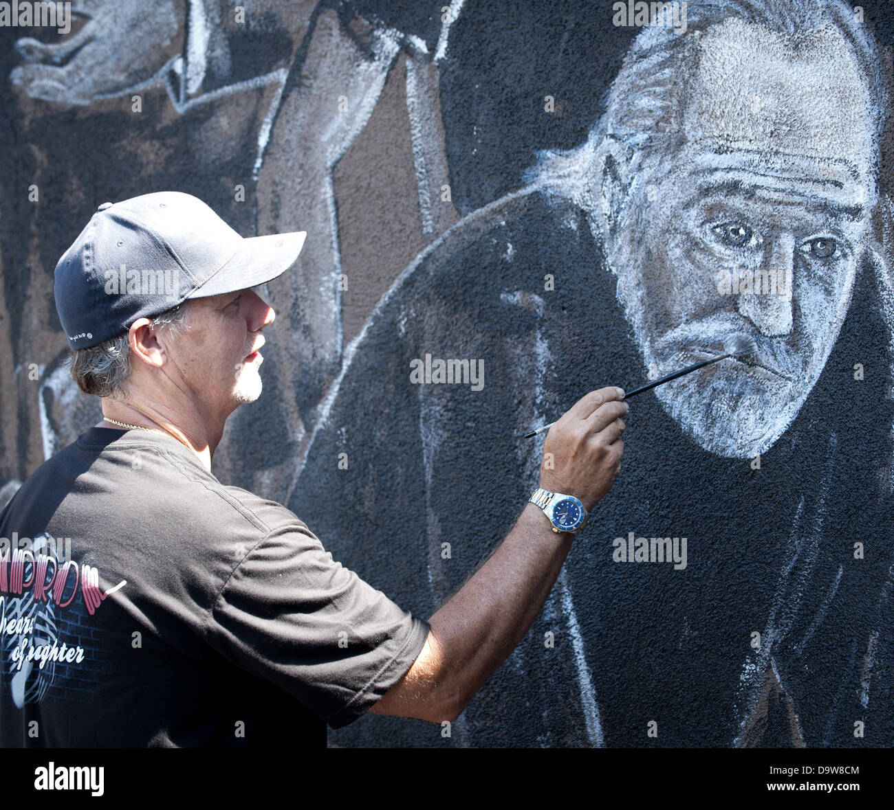 Los Angeles, California, USA. 26th June, 2013. WYLAND puts the finishing touches on his portrait of the late comic George Carlan---His nearly completed mural at the Hollywood Improve on Melrose Avenue in Los Angeles on Wednesday, June 26, 2013, features 57 well known comics in larger than life dimensions on the walls surrounding the entrance to the famed comedy club. WYAND and the Wyland Foundation support water conservation, coming together over the last several months with ''Comics For Water Conservation,'' in order to raise money to support the National Mayor's Challenge for Water Conserva Stock Photo