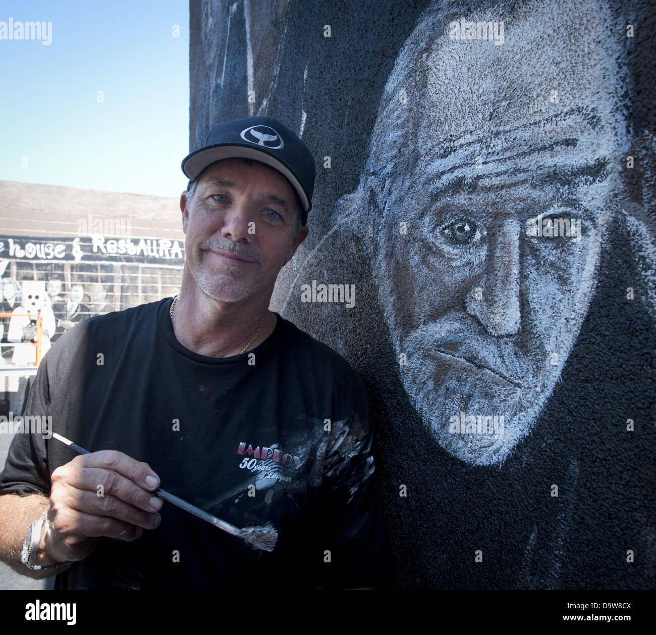 Los Angeles, California, USA. 26th June, 2013. WYLAND stands alongside his nearly completed mural at the Hollywood Improve on Melrose Avenue in Los Angeles on Wednesday, June 26, 2013. WYLAND painted 57 well known comics in larger than life dimensions on the walls surrounding the entrance to the famed comedy club. WYAND and the Wyland Foundation support water conservation, coming together over the last several months with ''Comics For Water Conservation,'' in order to raise money to support the National Mayor's Challenge for Water Conservation.'' In the photo Wyand alongside his portrait of Stock Photo