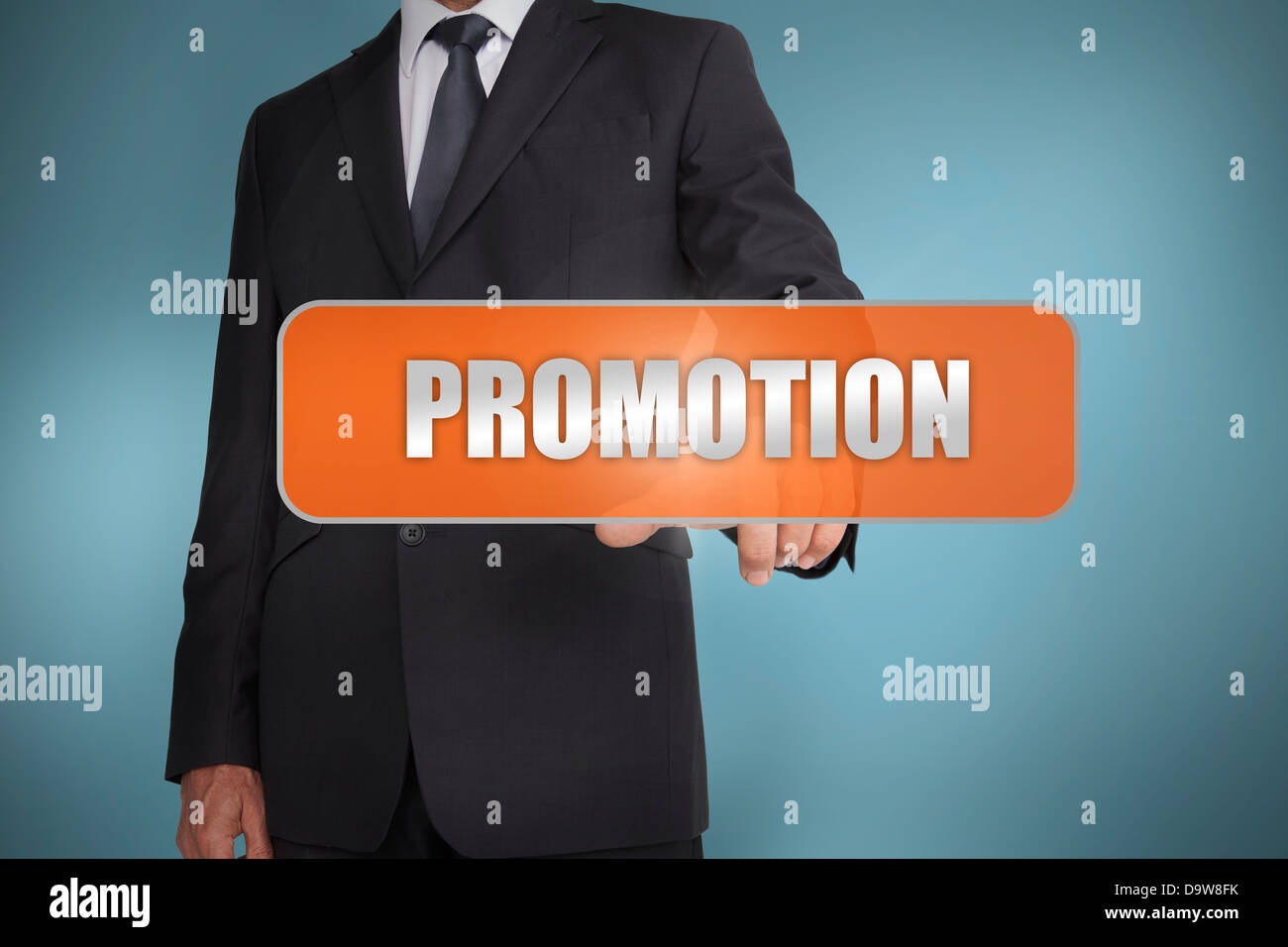 Businessman selecting the word promotion written on orange tag Stock Photo