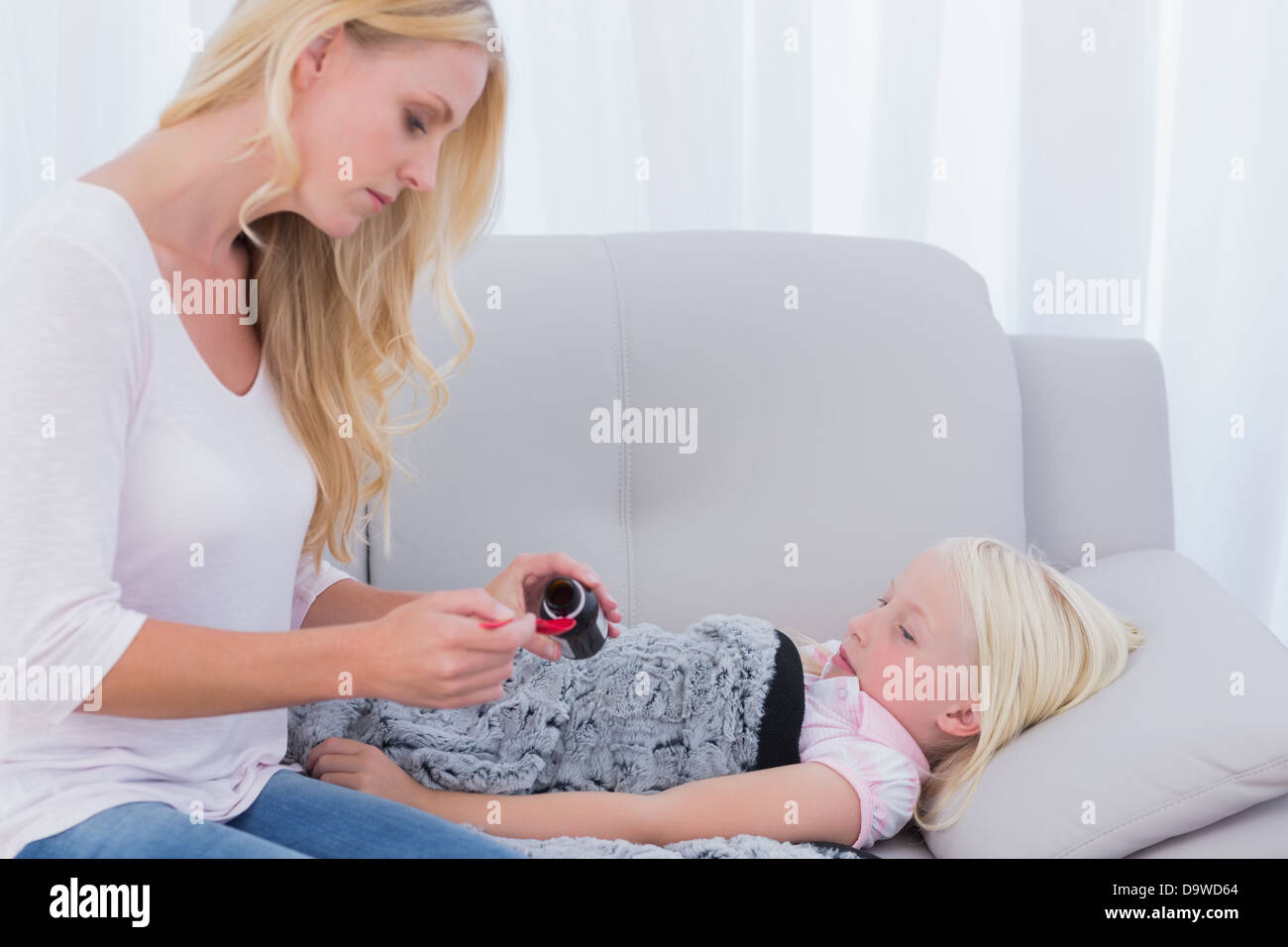 Mom giving her daughter medicine Stock Photo Alamy