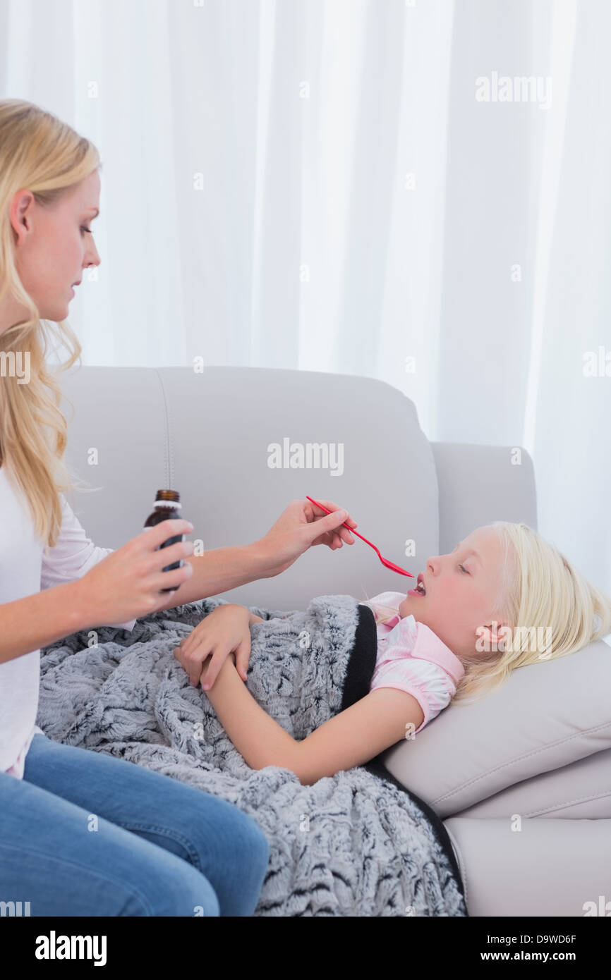 Mother giving her daughter cough medicine Stock Photo Alamy